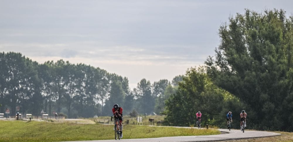 Renners op een dijkweg met uitzicht over de Betuwse polder