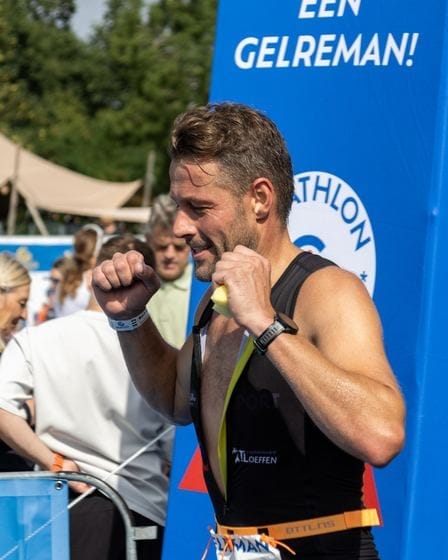 Teilnehmer mit seiner Medaille vor dem Banner 'Een Gelreman!'