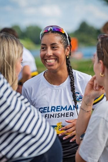 Teilnehmerin im Gelreman-Finishershirt wird von ihren Leuten empfangen