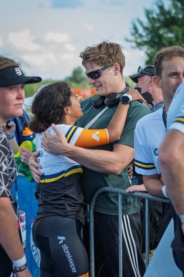 Des supporters étreignent une participante par-dessus la barrière