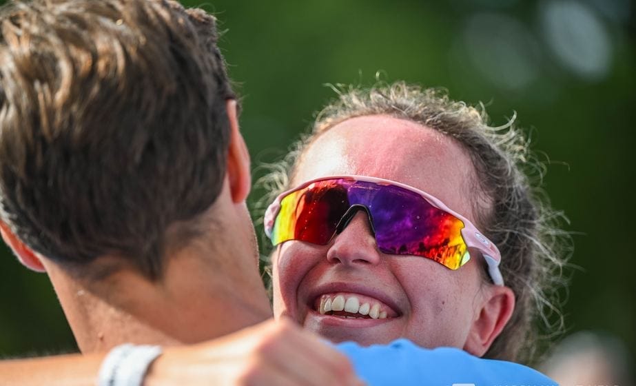 Une finisher rit dans les bras d'un supporter juste après la ligne