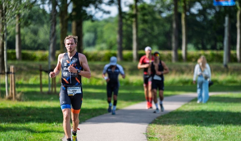 Lopers onder hoge populieren op een pad door het park
