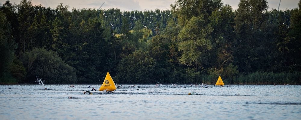 Yellow buoys in the Rijkerswoerdse lake with the treeline behind