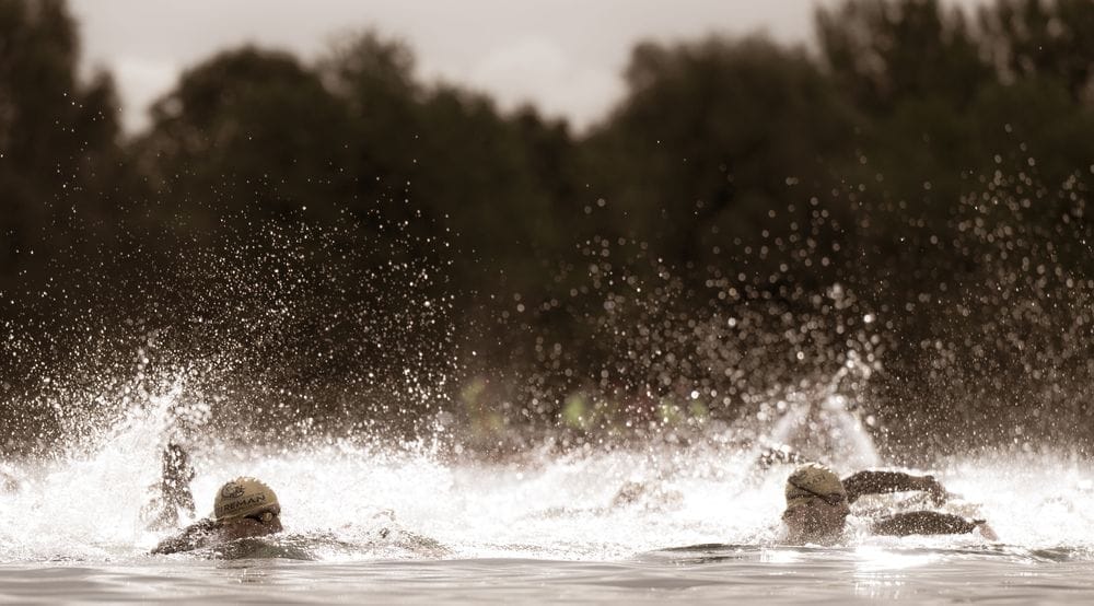 Swimmers in spraying water, backlit